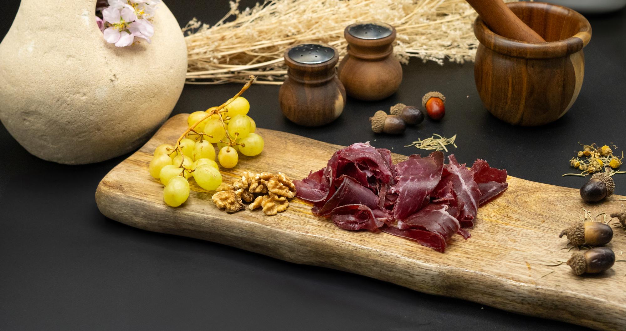 wooden board with cured slices and bread